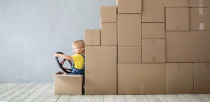 Enfant devant une pile de cartons en forme de camion