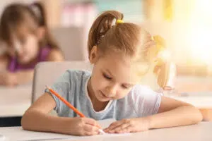 Petite fille qui dessine à l'école