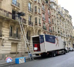 Photo d'un camion de déménagement dans la rue avec positionnement d'une échelle électrique