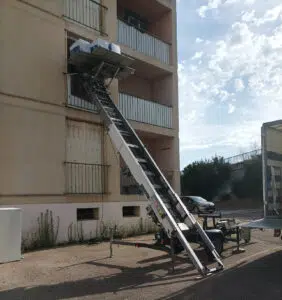 Photo d'un monte-meubles tracté installé sur la facade d'un immeuble