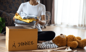 Femme qui met dans un carton des effets à donner